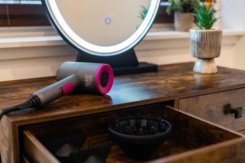 a blow dryer sitting on top of a wooden drawer at The City Escape - 5* stay in the heart of Glasgow! in Glasgow