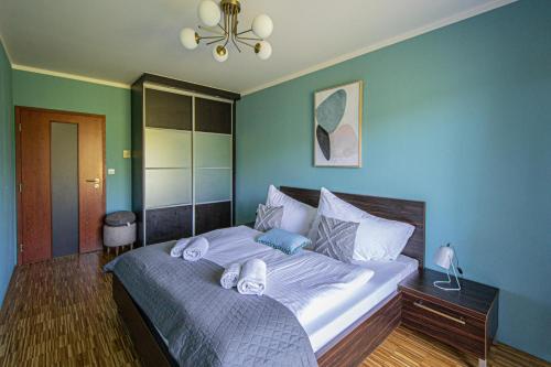 a bedroom with a large bed with blue walls at Park View Apartman with private garage and balcony in Prague