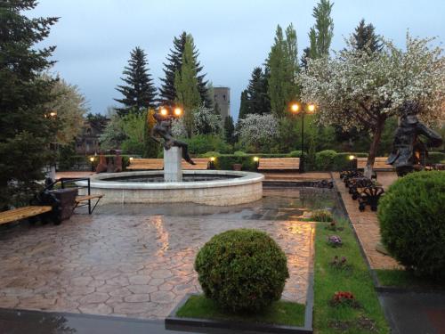 a fountain with two statues in a park at Nane Hotel in Gyumri