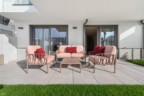 a patio with three chairs and a table with red pillows at Karl und Anton Boutique Apartments in Vienna