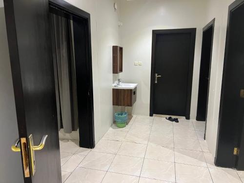 baño con 2 puertas negras y lavamanos en شقق قمة الرفاء للوحدات السكنيه, en Riad