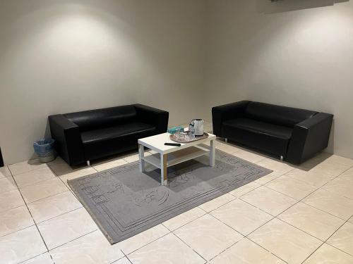 2 sillas de cuero negro y una mesa de centro en una habitación en شقق قمة الرفاء للوحدات السكنيه, en Riad