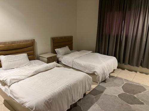 1 dormitorio con 2 camas y ventana en شقق قمة الرفاء للوحدات السكنيه, en Riad