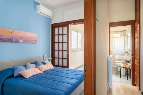 a bedroom with a blue bed and a bathroom at La Pomelia di Giò in Mondello