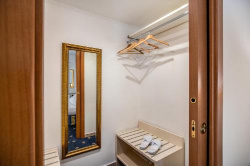 een badkamer met een spiegel en een paar schoenen bij Hotel Napoleon in Rome