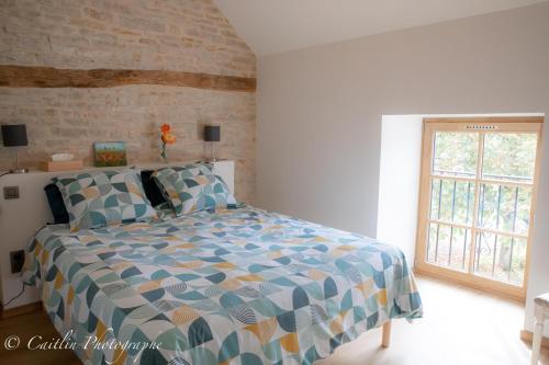 um quarto com uma cama e uma janela em Chez Agnès em Chailly-sur-Armançon