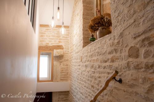 a hallway with a stone wall and a window at Chez Agnès in Chailly-sur-Armançon