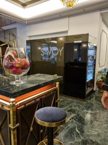 a bar in a lobby with a bowl of fruit on a counter at Savoy Hotel in Piraeus