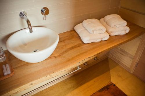 a bathroom with a sink and towels on a wooden counter at Palafito 1326 Hotel Boutique in Castro
