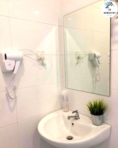 a white bathroom with a sink and a mirror at THE WAVE 3 ROOMS & 2 BATH CONDO - Near JONKER in Melaka