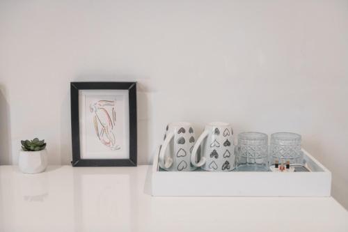a shelf with a picture and glasses and a frame at Privilege Suite in Tal-Pietà