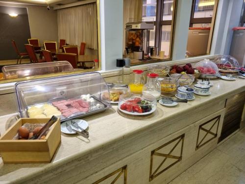 a buffet line with food on it in a restaurant at Savoy Hotel in Piraeus