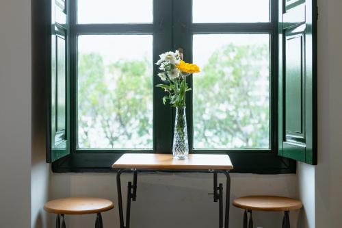 a vase of flowers sitting on a table in front of a window at Privilege Suite in Tal-Pietà