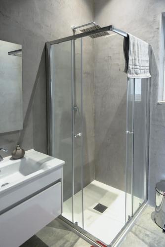 a shower with a glass door next to a sink at Privilege Suite in Tal-Pietà