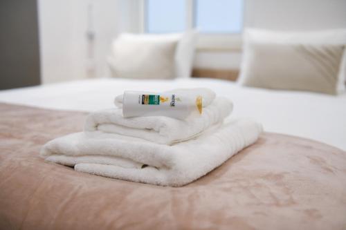 a pile of towels on top of a bed at Privilege Suite in Tal-Pietà