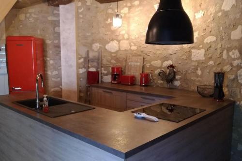 a kitchen with a sink and a red refrigerator at La tour du logis, gîte 4 * à 15 min du Futuroscope 