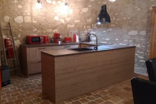 a kitchen with a counter with a sink and a microwave at La tour du logis, gîte 4 * à 15 min du Futuroscope 