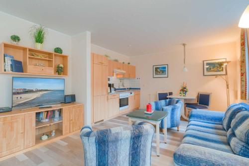 sala de estar con sillas azules y TV en Haus Margarete Whg_ 2 en Binz