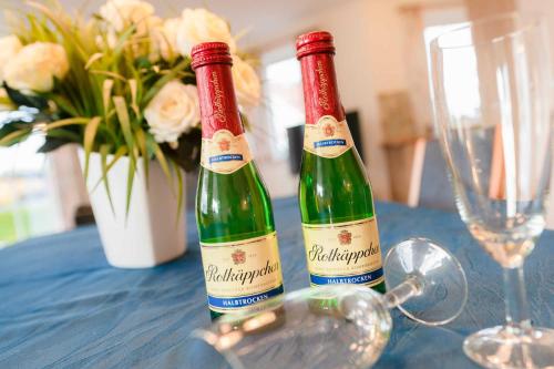 two bottles of wine sitting on a table with a glass at Strandhaus Thiessow Whg_ 1 in Thiessow