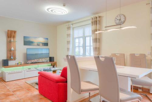 - un salon avec une table et une chaise rouge dans l'établissement Villa Bakenberg, à Binz