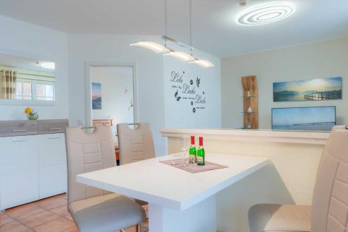 - une cuisine blanche avec une table et des chaises blanches dans l'établissement Villa Bakenberg, à Binz