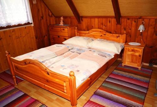 a bedroom with a large wooden bed in a room at Chata na Plantáži in Habovka
