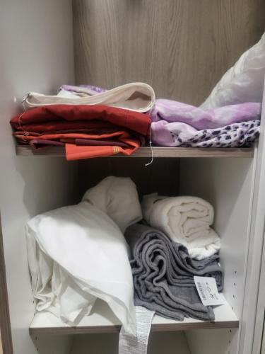 a closet filled with lots of towels and pillows at Habitaciones con baño compartido en bonito Apartamento en Badalona in Badalona