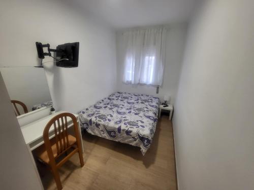 um pequeno quarto com uma cama e uma cadeira em Habitaciones con baño compartido en bonito Apartamento en Badalona em Badalona