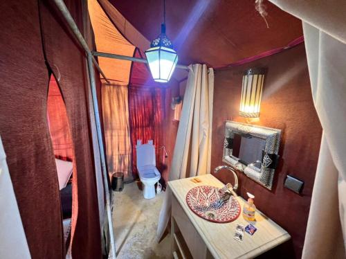 a view of a bathroom with a sink and a tv at Roses desert camp in Merzouga