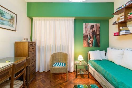 1 dormitorio con paredes verdes, 1 cama y escritorio en Habitación Verde en Buenos Aires