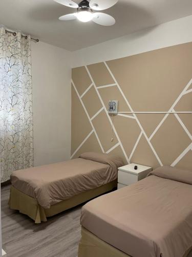 una camera con 2 letti e un ventilatore a soffitto di Residence Europa a Piacenza