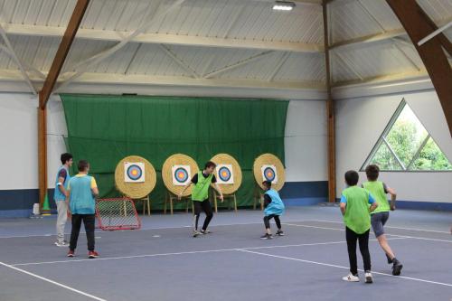un groupe de personnes jouant sur un court de tennis dans l'établissement Camping Le Val de Landrouet, à Merdrignac