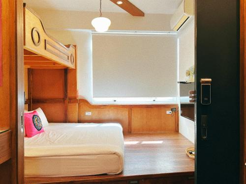 a small room with a bunk bed in a room at Dock Inn in Tainan