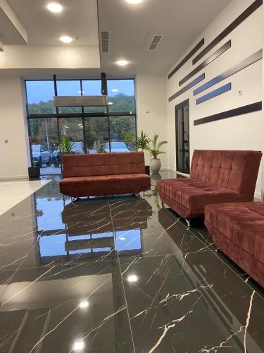 a living room with two brown leather couches and a lobby at Tsaghkadzor Alvina complex in Tsaghkadzor
