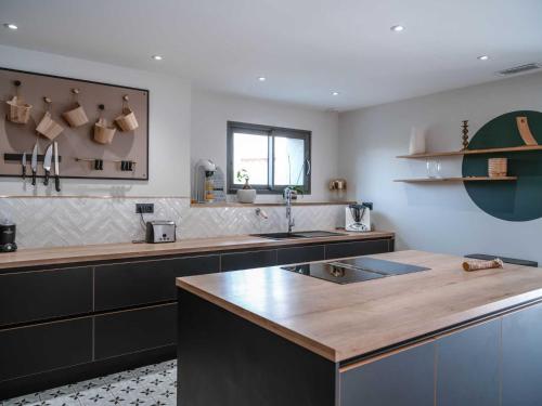 a kitchen with a sink and a counter top at La Maison du Bonheur - Grande Piscine & Terrasse in Brens
