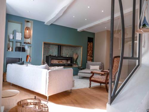 een woonkamer met een witte bank en een open haard bij La Maison du Bonheur - Grande Piscine & Terrasse in Brens
