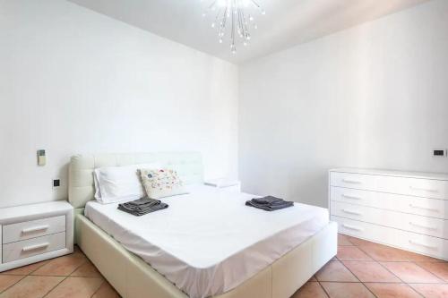 a white bedroom with a bed and a dresser at SUITE con 2 Balconi - 6 Guest in Prato