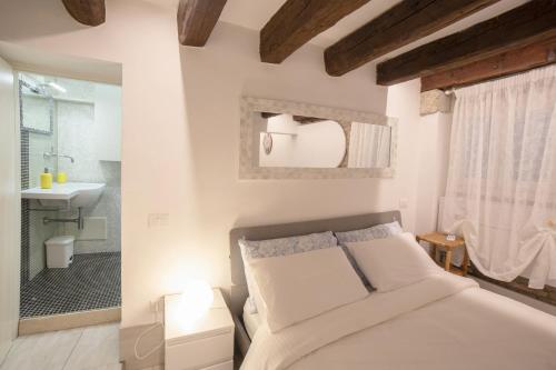 ein Schlafzimmer mit einem Bett und ein Badezimmer mit einem Waschbecken in der Unterkunft La Vida by Venicevillas in Venedig