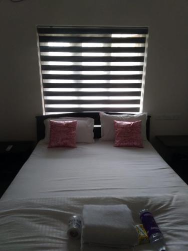 a large bed with two towels on it with a window at Dune Homestay in Alleppey