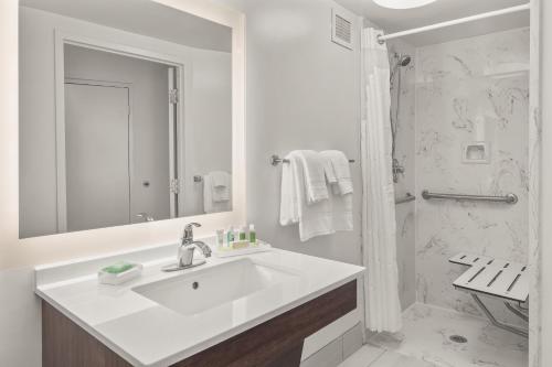 a white bathroom with a sink and a shower at Holiday Inn Charleston-Riverview by IHG in Charleston
