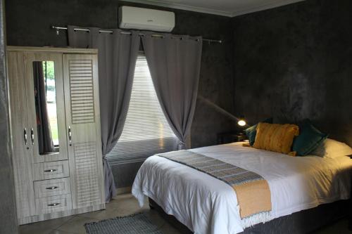 a bedroom with a large bed and a window at A Step Ahead in Klerksdorp
