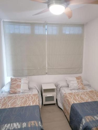 sypialnia z dwoma łóżkami i stołem z lampą w obiekcie Quiet & Bright Apartment with private garden w mieście Maspalomas