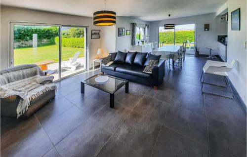 ein Wohnzimmer mit einer schwarzen Couch und einem Tisch in der Unterkunft Holiday Home Lilia Plouguerneau With Sea View 02 in Plouguerneau