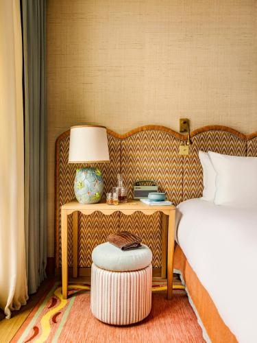 a bedroom with a bed and a table with a lamp at La Fantaisie in Paris
