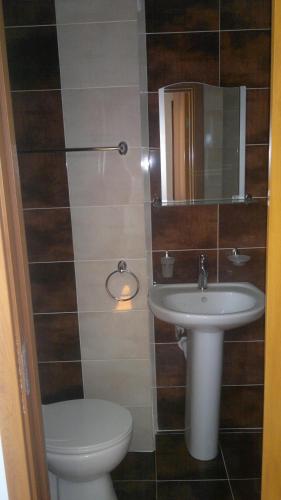 a bathroom with a sink and a toilet and a mirror at Kyurkchievi Guest House in Sapareva Banya