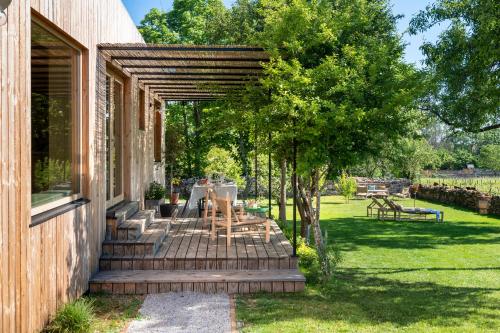 eine Terrasse mit einem Tisch und Stühlen unter einer Pergola in der Unterkunft Casa Ladoit - maison d'architecte vue sur vignes in Mercurey