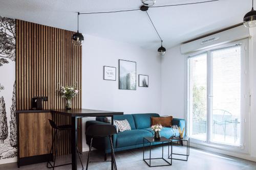 uma sala de estar com um sofá azul e uma mesa em Henri IV - 2 Pièces - Parking gratuit em Billère