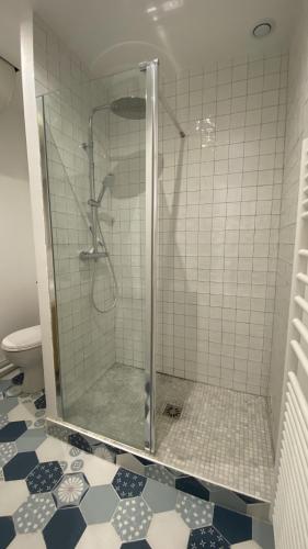 une douche avec une porte vitrée dans une salle de bain dans l'établissement L'escapade, au Crotoy