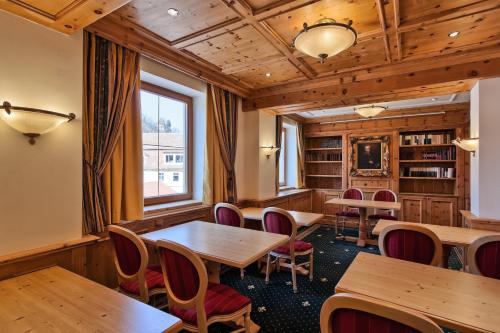 a room with wooden tables and chairs and a window at Mercure Sighisoara Binderbubi Hotel & Spa in Sighişoara