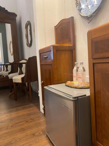 a kitchen with a refrigerator and a table with bottles of water at Ortigia Twin Rooms in Syracuse